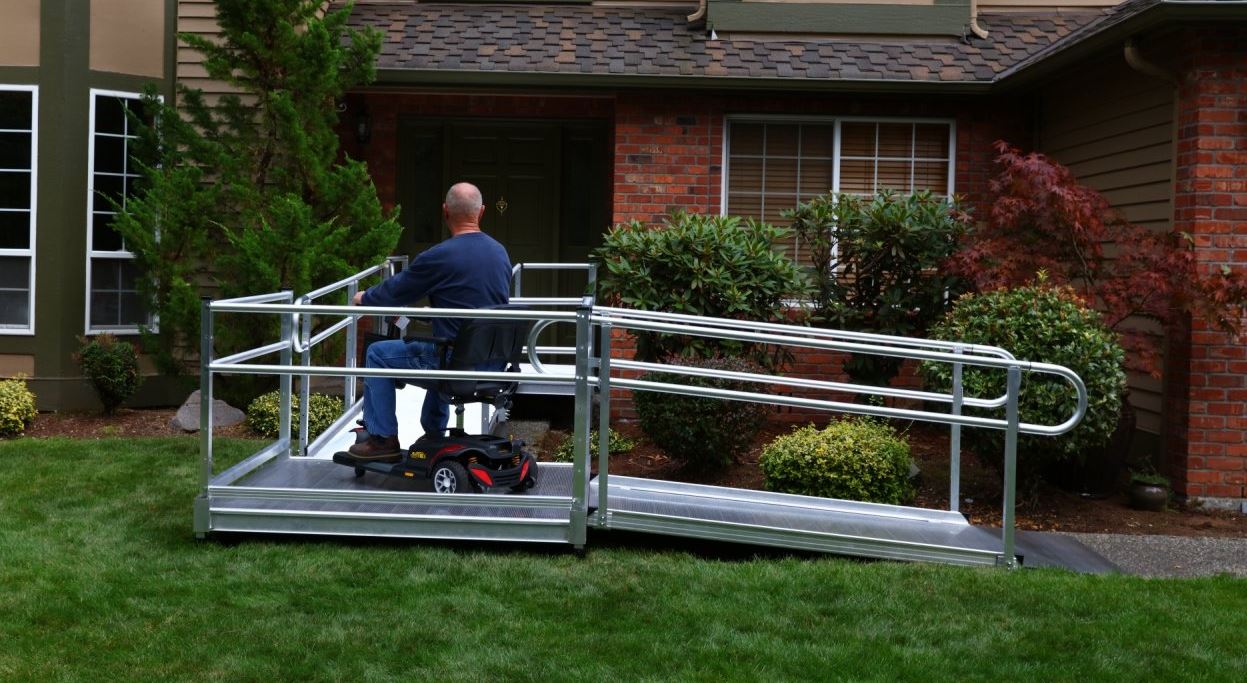 aluminum modular wheelchair ramp provides man on scooter safe access to front entrance of his home