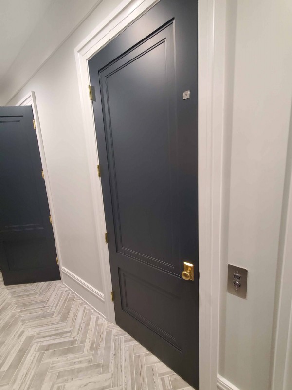 navy blue paneled elvator swing door in home on Chicago northside