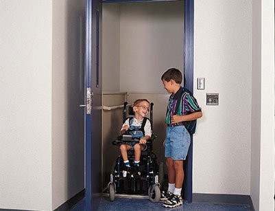 two-boys-getting-out-of-enclosed-commercial-wheelchair-lift-in-school